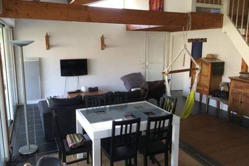 un salon avec une table et des chaises dans l'établissement Maison Girolle, à Vendays-Montalivet