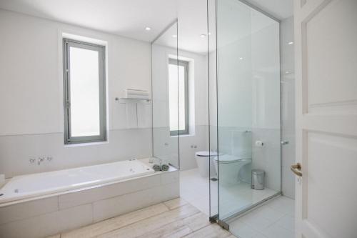 a white bathroom with a tub and a toilet at Estancia La Paz Hotel in Ascochinga