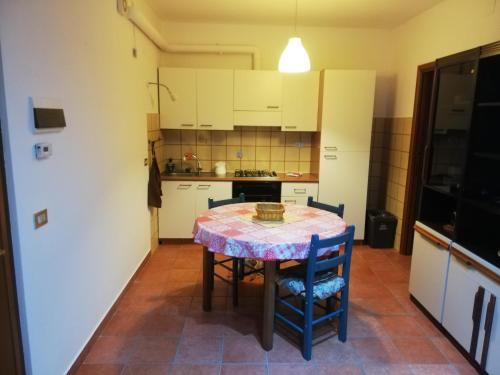 uma cozinha com mesa e cadeiras num quarto em Casa Rosaguta em Vescina