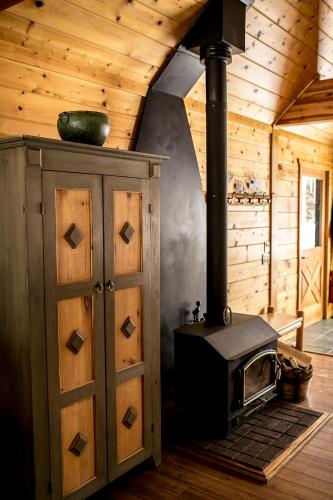 a stove in a room with a wooden ceiling at Beyul Retreat in Meredith
