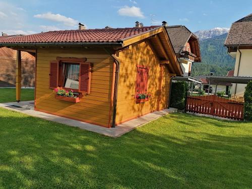 Cabaña de madera pequeña en un patio con césped verde en Ferienhaus Mentil, en Greifenburg