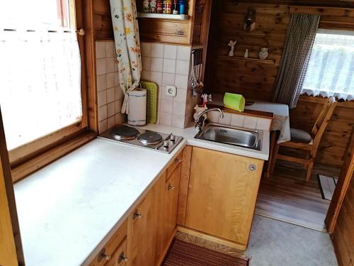 uma pequena cozinha com um lavatório e um fogão em Ferienhaus Mentil em Greifenburg