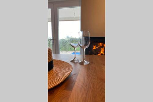 two wine glasses sitting on a table next to a fireplace at Villa Stanzietta Novigrad for 10 at Olive orchard in Novigrad Istria