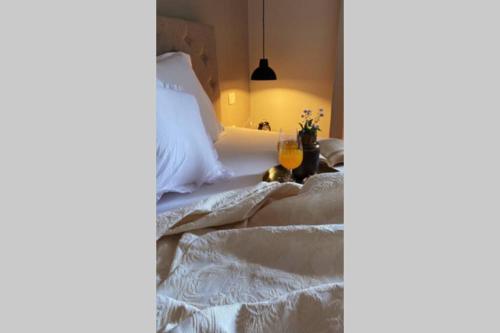 a bed with white sheets and a glass of orange juice at Villa Stanzietta Novigrad for 10 at Olive orchard in Novigrad Istria