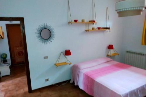 Habitación blanca con cama y espejo en L' Agave - Appartamento nel cuore del Chianti en Castelnuovo Berardenga