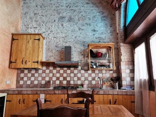 una cucina con armadi in legno e tavolo di Piazzetta Del Forno - Monolocale con Soppalco ad Assergi
