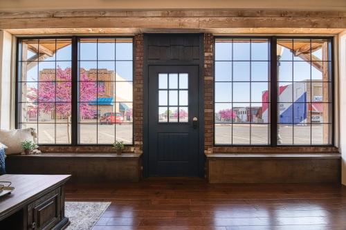 an empty room with a door and windows at Bluebird in Elk City