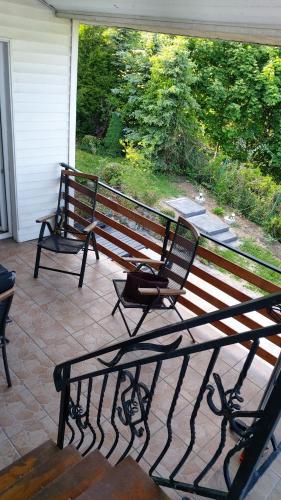 two benches sitting on a porch with a view at SORKWITY- Pensjonat - STARY GIELĄD in Sorkwity
