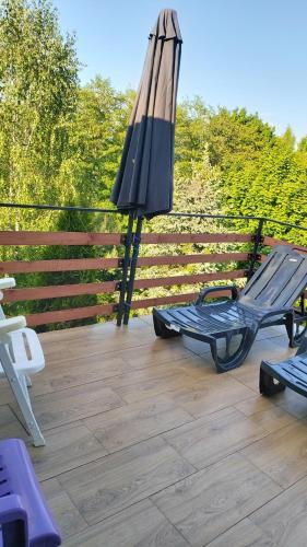 a patio with a bench and an umbrella on a deck at SORKWITY- Pensjonat - STARY GIELĄD in Sorkwity