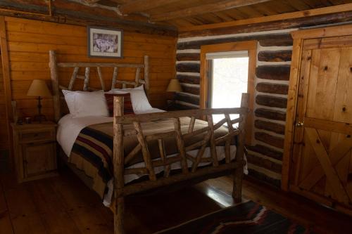 a bedroom with a bed in a log cabin at Beyul Retreat in Meredith