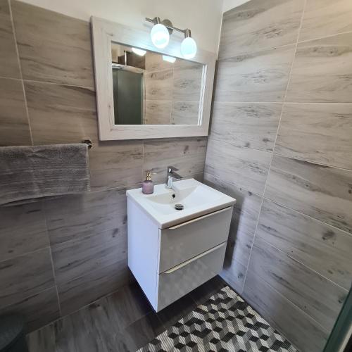 a bathroom with a white sink and a mirror at Apartament OLTO Mikołajki in Mikołajki