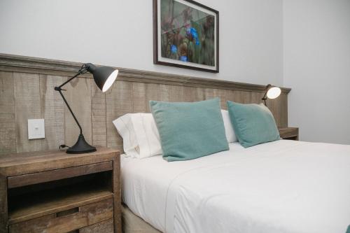 a bedroom with a bed with a lamp and pillows at Estancia La Paz Hotel in Ascochinga