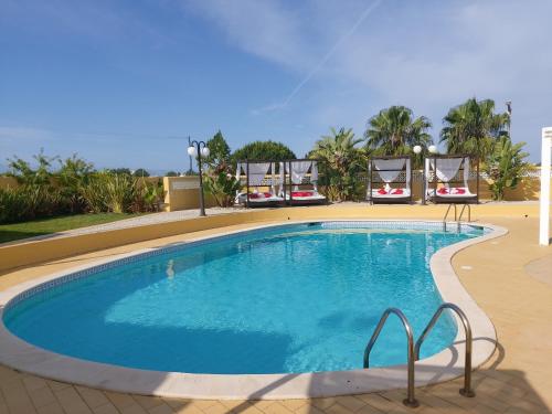 a large swimming pool with chairs around it at Quinta Nova Relax & Spa - Vale del Rey in Carvoeiro