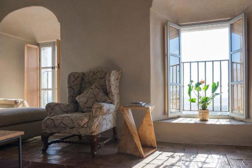 uma sala de estar com uma cadeira e uma janela em La Pileta em Vejer de la Frontera