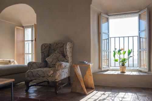 a living room with a chair and a window at La Pileta in Vejer de la Frontera