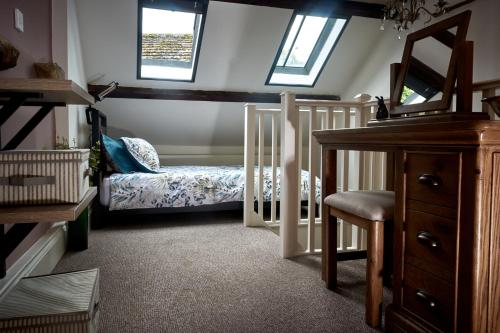 a small room with a crib and a bed in it at Maltings Cottage in Barnard Castle