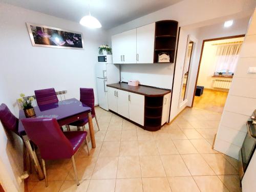 ムロンゴヴォにあるApartament Sprężynkaのキッチン、ダイニングルーム(テーブル、紫色の椅子付)