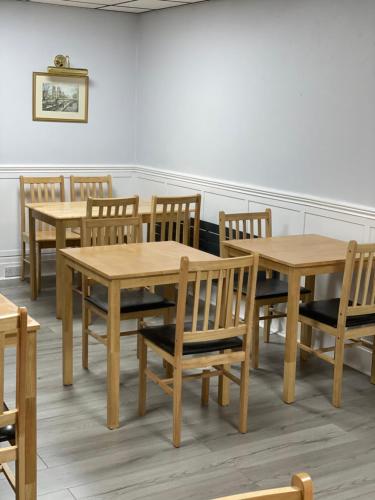 a group of wooden tables and chairs in a room at Kingscliff in Blackpool