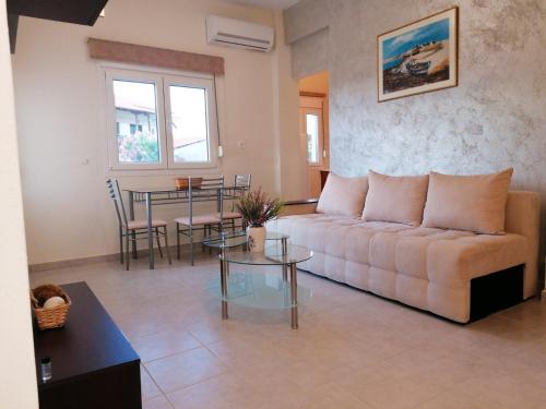 ein Wohnzimmer mit einem Sofa und einem Tisch in der Unterkunft Magdalena Seaside Apartments in Nea Roda