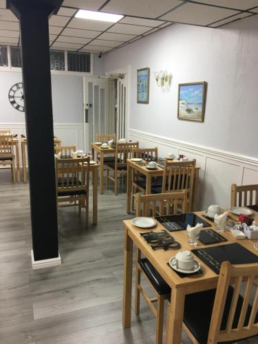 a dining room with wooden tables and chairs at Kingscliff in Blackpool