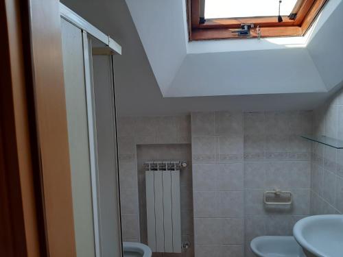 een badkamer met een douche, een wastafel en een raam bij Mansarda Gardenia in Pescara