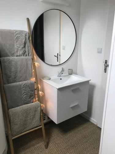 a bathroom with a sink and a mirror and a chair at Gîte d’Eros in Saint-Valery-sur-Somme