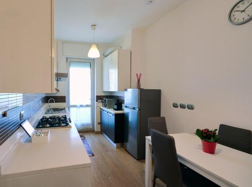 a kitchen with a refrigerator and a table with chairs at Farini Apartment in Milan