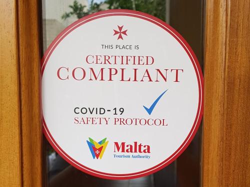 a sign for a certified compliant sign on a door at Rivotorto Retreat House in Birkirkara