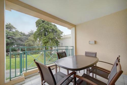 un balcon avec une table et des chaises et une grande fenêtre dans l'établissement IMMOGROOM - 3 Rooms - Renovated - Pool - Air conditioning - Parking -, à Cannes