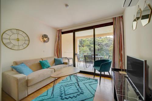 un salon avec un canapé et une télévision dans l'établissement IMMOGROOM - 3 Rooms - Renovated - Pool - Air conditioning - Parking -, à Cannes