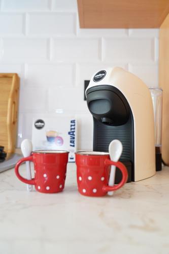 two red cups on a counter next to a toaster at APPARTAMENTO AL FORTE in Rivoli Veronese