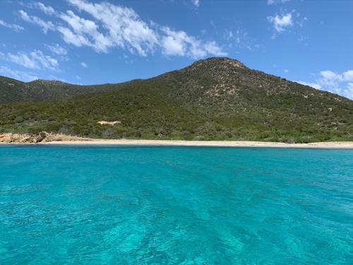 a view of the ocean with a mountain in the background at S’apposentu in Solinas