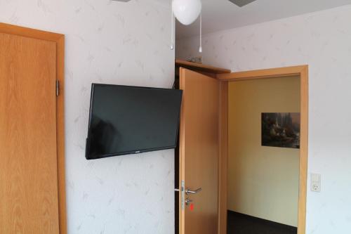 a flat screen tv hanging on a wall next to a door at Gasthaus Zur Sonne in Freiburg im Breisgau