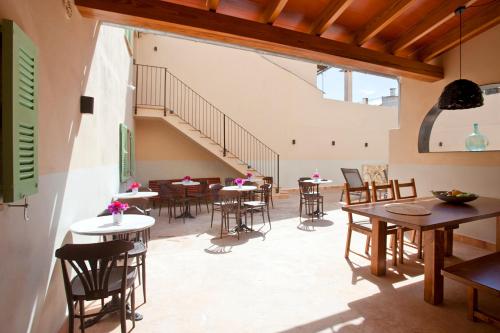a room with tables and chairs and a staircase at Casal de Petra - Rooms & Pool by My Rooms Hotels TI in Petra