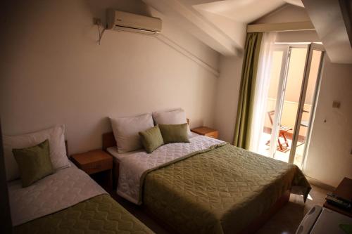 Cette chambre comprend 2 lits et une fenêtre. dans l'établissement Apartments Stari Ribar, à Budva