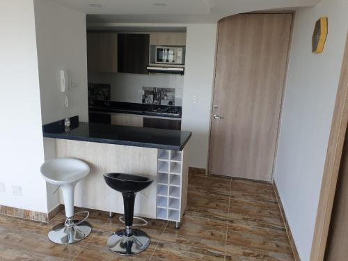 a kitchen with a counter and two stools in a room at Puerto Azul Club House Apartamento Familiar in Ricaurte