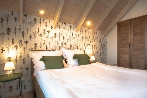 ブワディスワボボにあるZatoka Mewのベッドルーム1室(花が飾られた壁の白い大型ベッド1台付)
