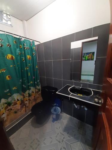 y baño con lavabo, aseo y ducha. en Hostal Selvatrip en Leticia