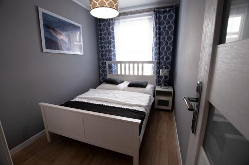 un piccolo letto in una stanza con una finestra di Apartament IKAR - 2 pokojowy przy morzu z balkonem a Pobierowo