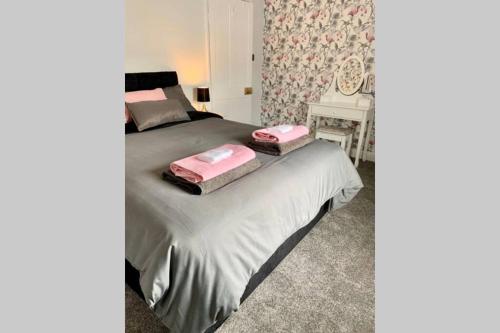 a bedroom with a bed with two pink towels on it at Durham House - Fantastic Location and Great Price in Scarborough in Scarborough