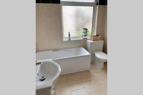 a bathroom with a tub and a toilet and a window at Durham House - Fantastic Location and Great Price in Scarborough in Scarborough