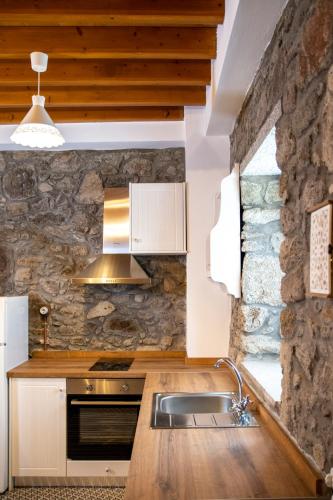 a kitchen with a sink and a stone wall at Samaradiko in Kondiás