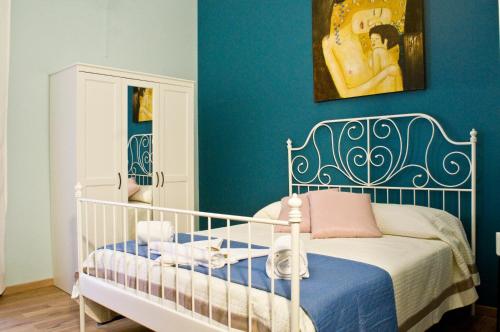 Schlafzimmer mit einem weißen Kinderbett und blauen Wänden in der Unterkunft B&B Affittacamere Trigona in Misterbianco