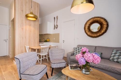 ein Wohnzimmer mit einem Sofa und einem Tisch mit Blumen darauf in der Unterkunft AH Design Luxury Apartments in Opatija
