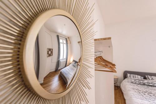 a mirror on a wall in a room with a bed at L'haussmannien - Spacieux 4 chambres - Centre - Gare in Reims