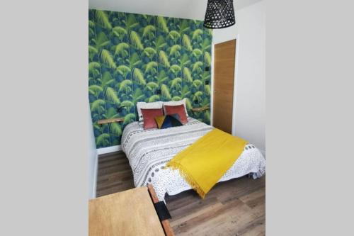 a bedroom with a bed with a large green wall at La Petite Maison Des Marais in Bourgneuf-en-Retz