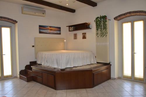 ein Schlafzimmer mit einem Bett in einem Zimmer mit Fenstern in der Unterkunft Domida Apartment in Bari