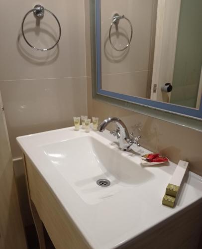 a bathroom with a white sink and a mirror at Villa Nostalgia Lentas No1 in Léntas