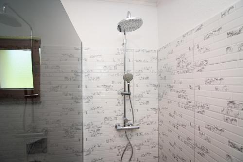 a shower in a bathroom with writing on the wall at Oasis of peace in Bihać