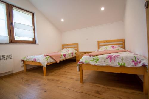 two twin beds in a room with a window at Oasis of peace in Bihać